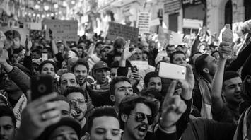 Crowd of protesters raising hands and holding signs