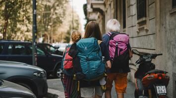 A group of travelers with backpacks walking down a European street