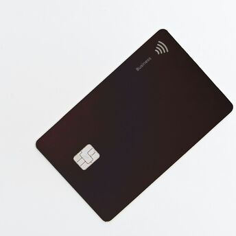 Black credit card with contactless symbol on white background