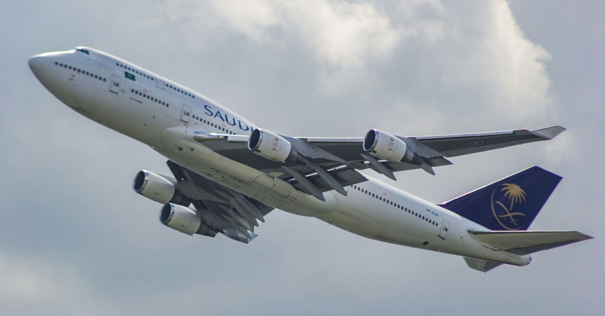 Saudia Airlines Boeing 747-400 aircraft taking off against a cloudy sky