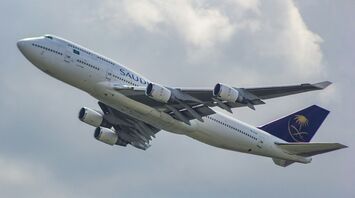 Saudia Airlines Boeing 747-400 aircraft taking off against a cloudy sky