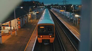 Train pulling into an empty rural station at dusk