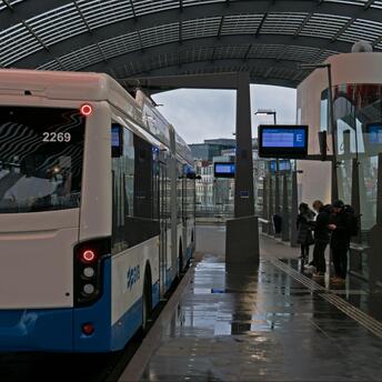 Modern bus GVB at a sheltered station with kids in Amsterdam