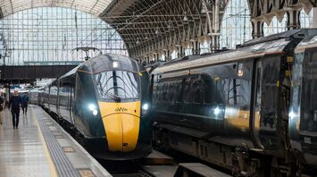 A Great Western Railway (GWR) train arrives at a platform under an arched, historic train station roof