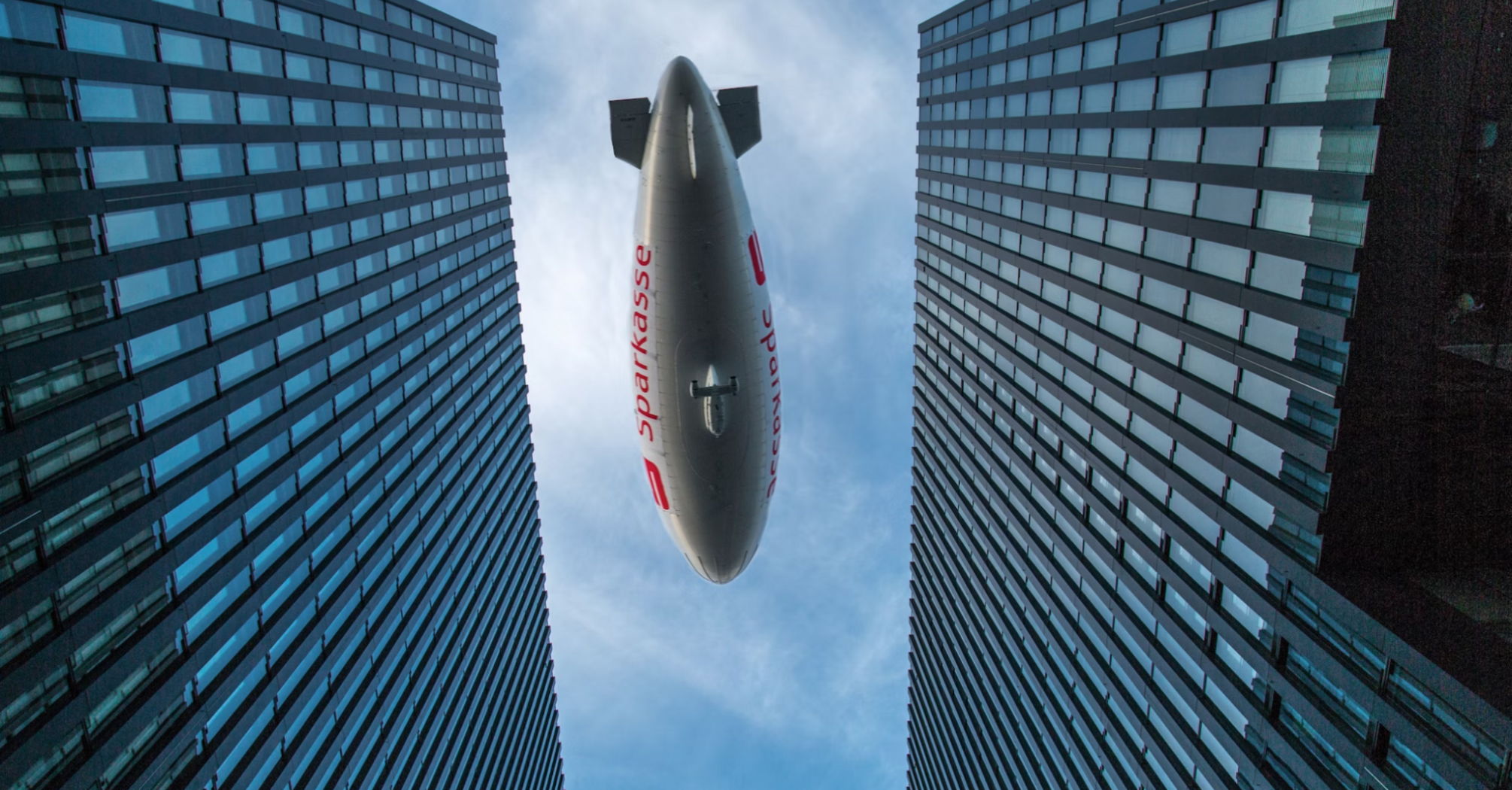 Airship flying between modern high-rise buildings