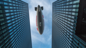 Airship flying between modern high-rise buildings