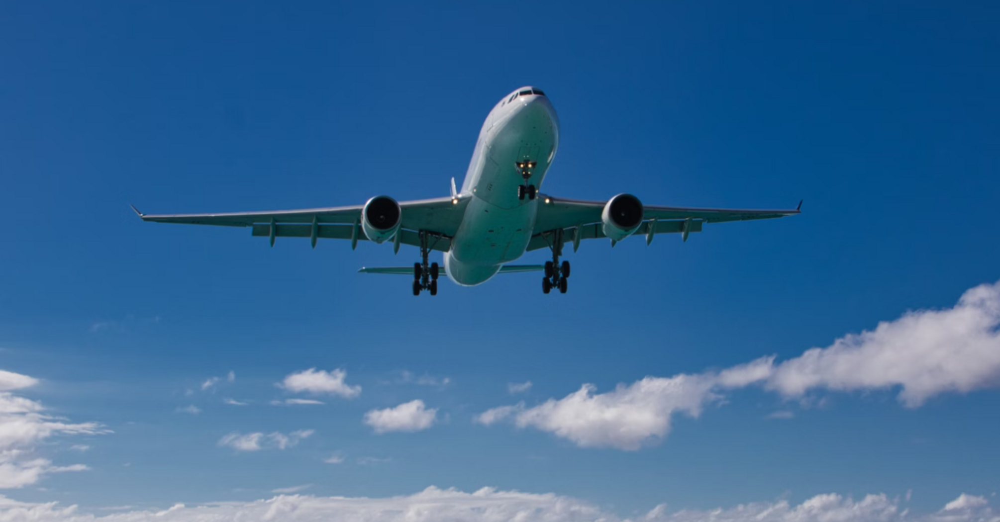 Airplane flying over a beach towards the ocean