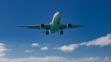 Airplane flying over a beach towards the ocean