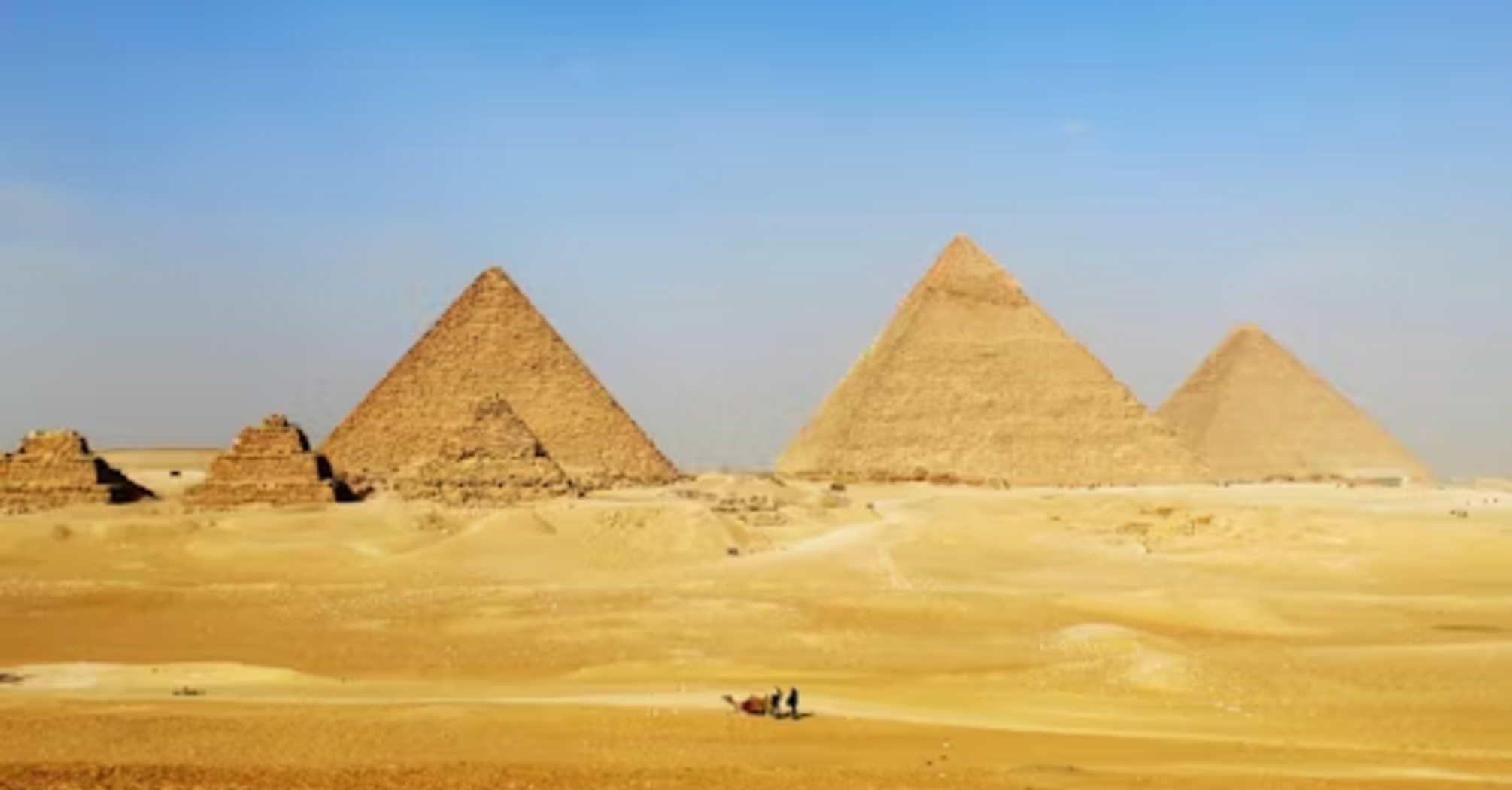 Pyramids of Giza standing tall in the desert under a clear blue sky