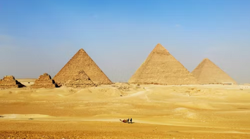 Pyramids of Giza standing tall in the desert under a clear blue sky