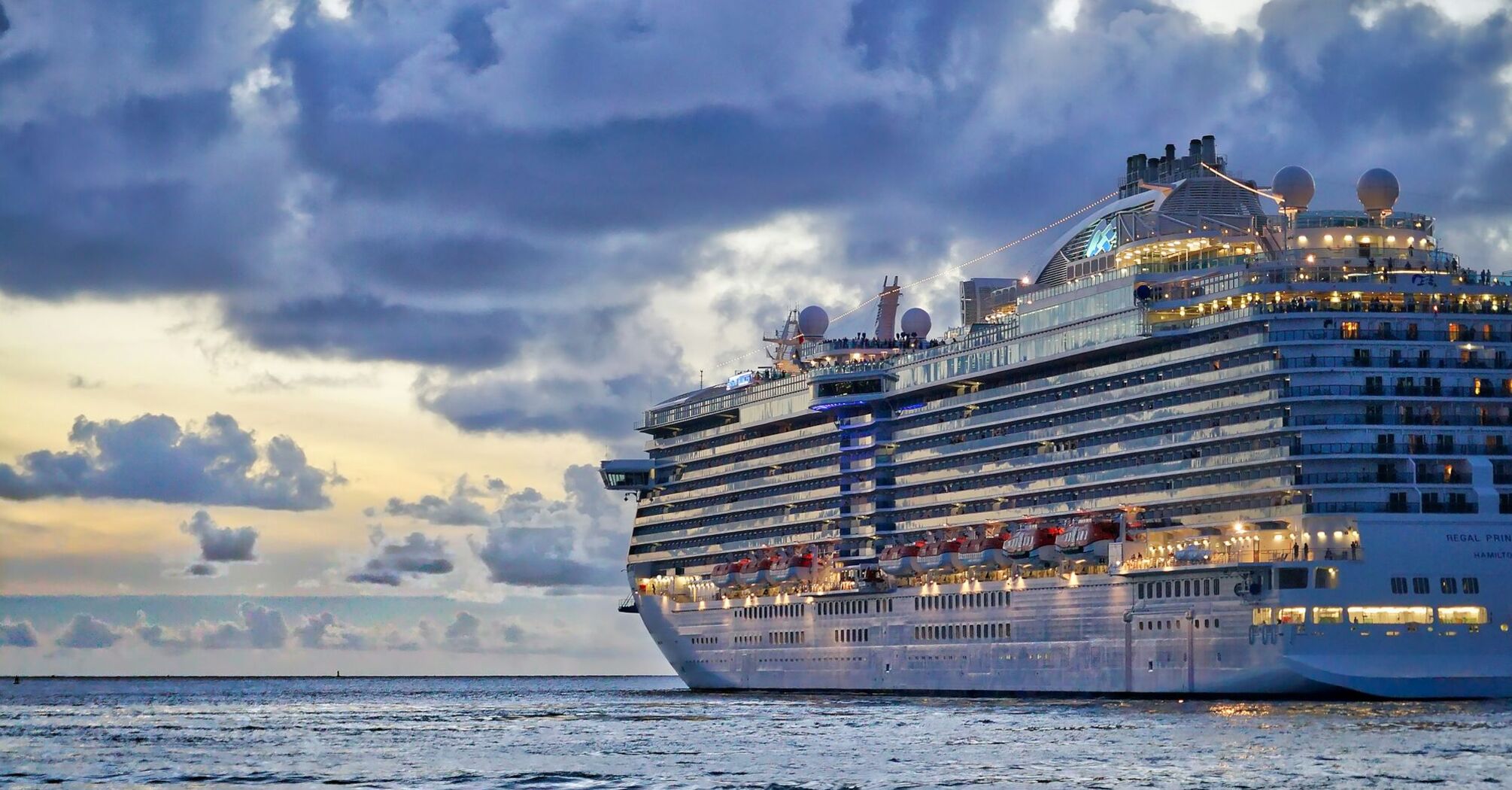 A luxury cruise ship at sea under cloudy skies