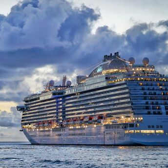 A luxury cruise ship at sea under cloudy skies