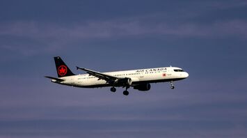 Air Canada airplane in flight against a clear sky