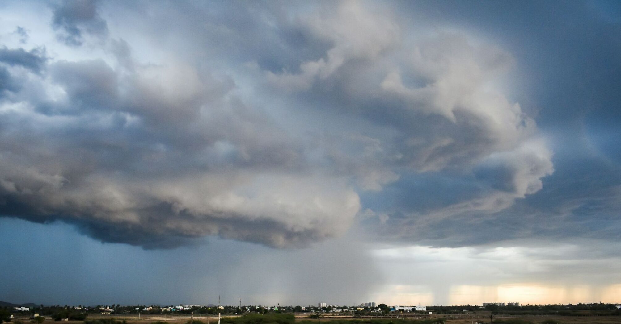 Dark storm clouds over a cityscape during heavy rainfall