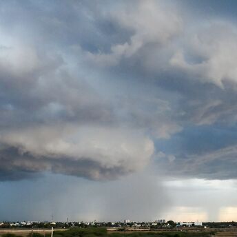 Dark storm clouds over a cityscape during heavy rainfall
