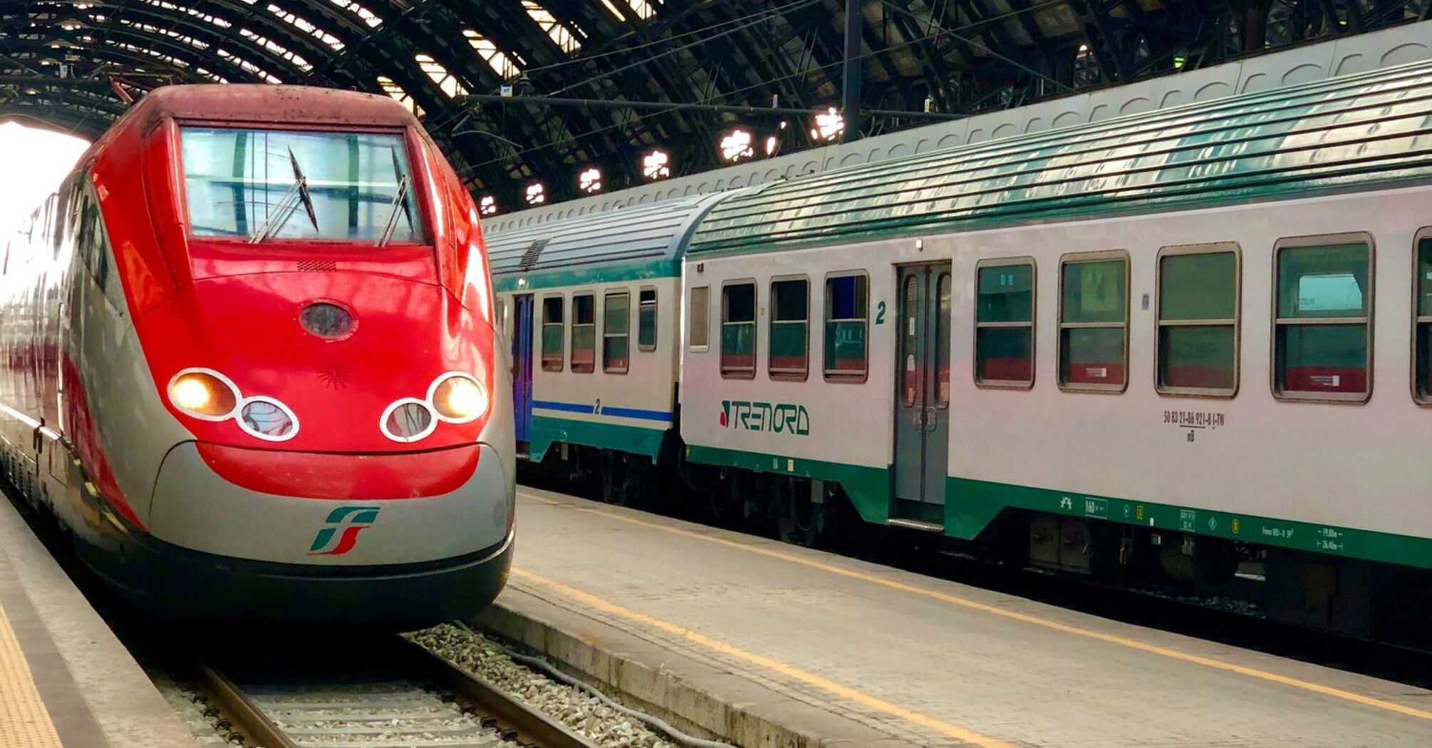 RFI train stationed at Milan railway terminal under an arched roof