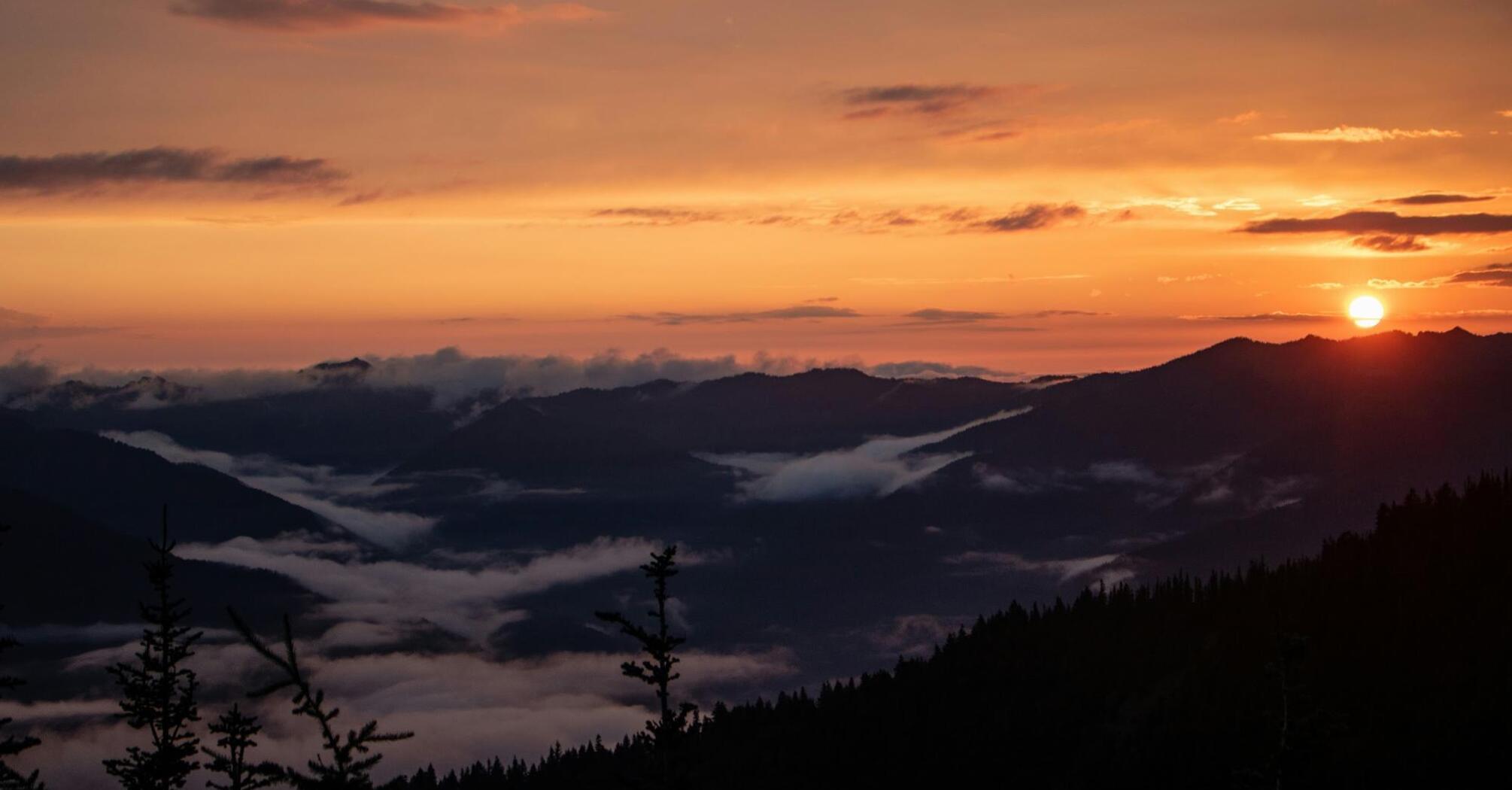 Sunset view over mountain ranges with misty valleys