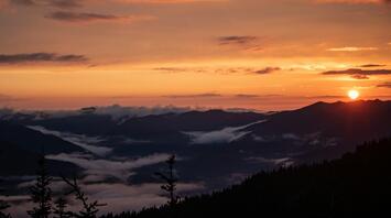 Sunset view over mountain ranges with misty valleys