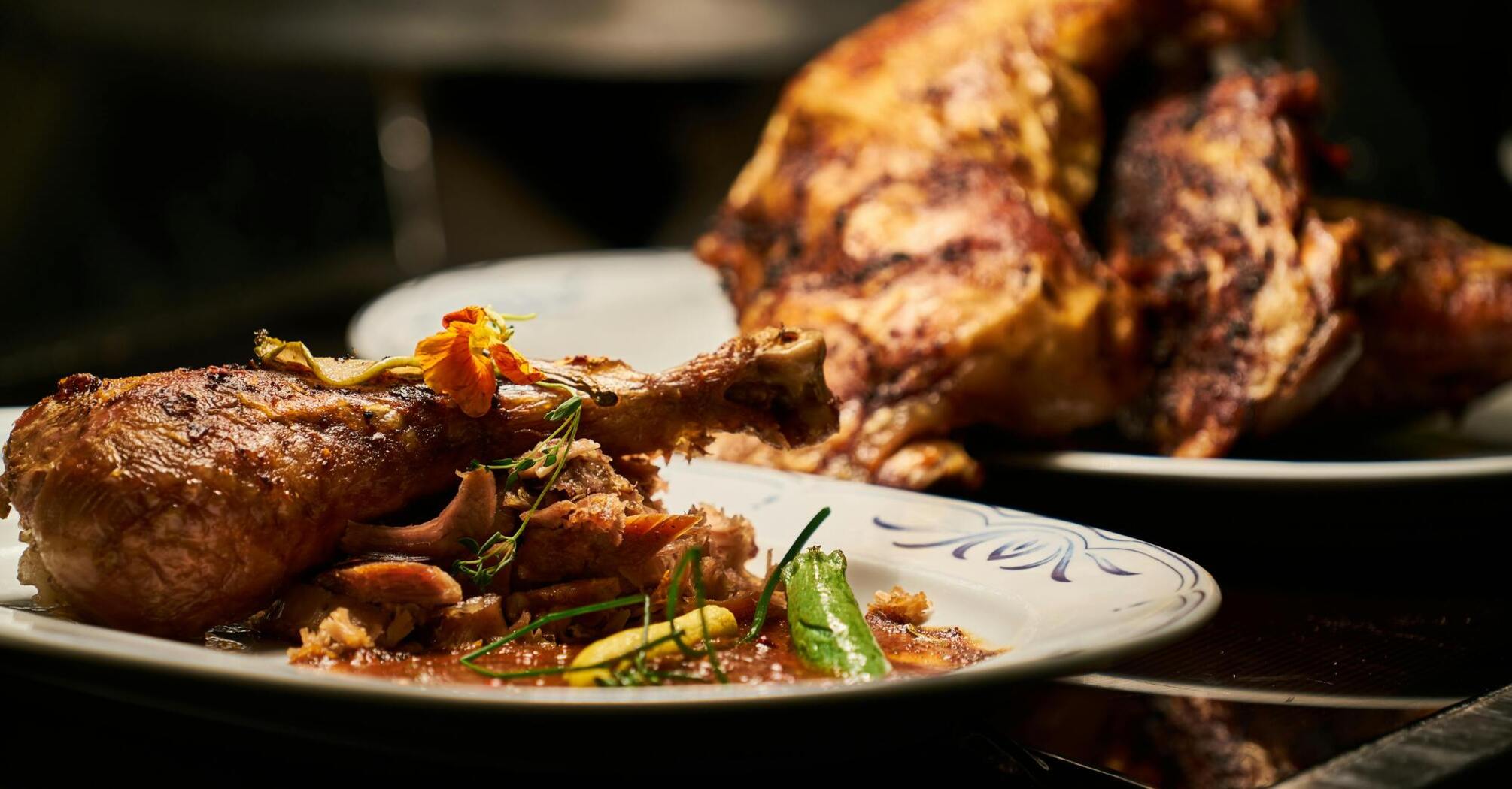 Close-up of roasted meat with garnish on a plate