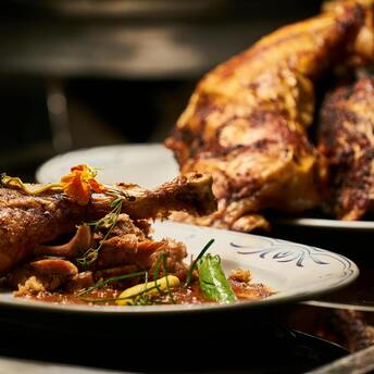 Close-up of roasted meat with garnish on a plate