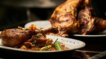 Close-up of roasted meat with garnish on a plate