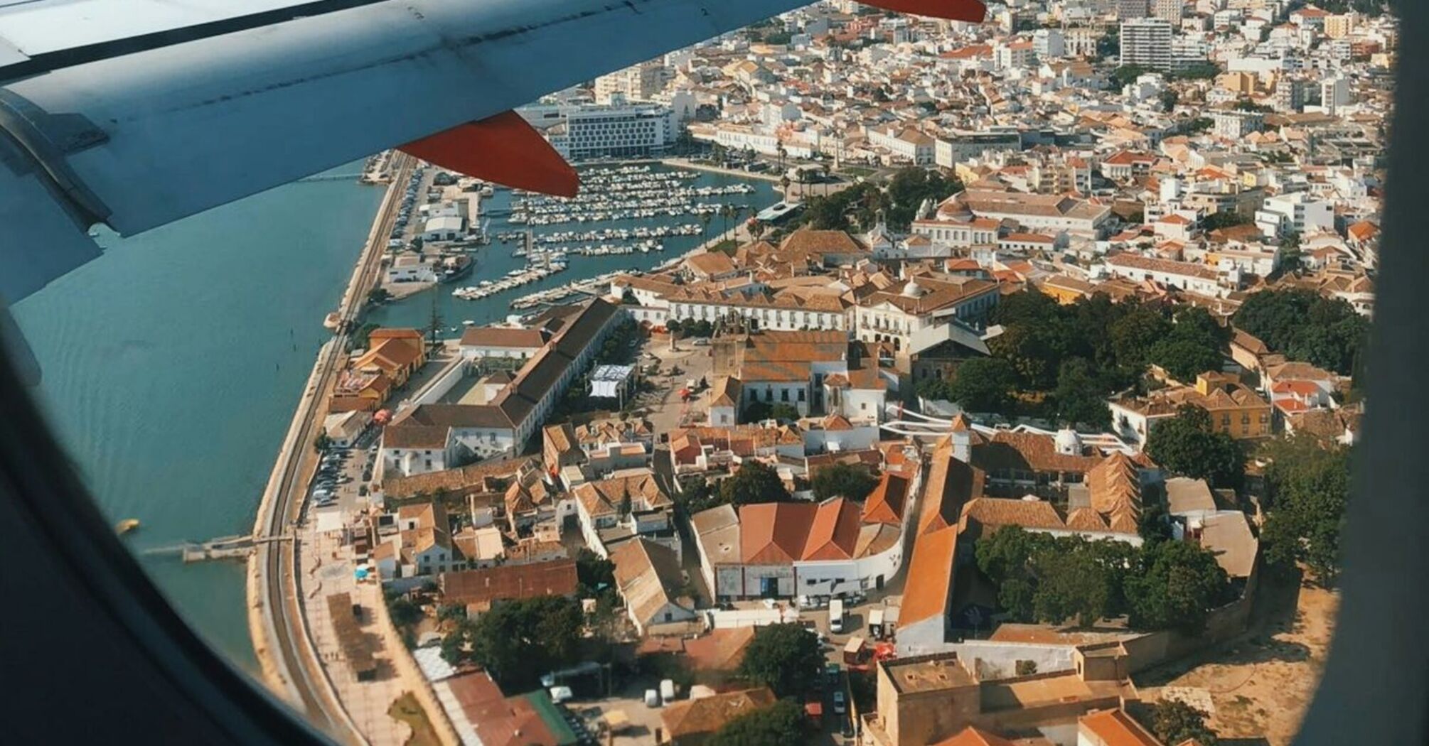 View of Faro city and harbor from an airplane window, showcasing the coastal town's charm