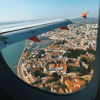 View of Faro city and harbor from an airplane window, showcasing the coastal town's charm