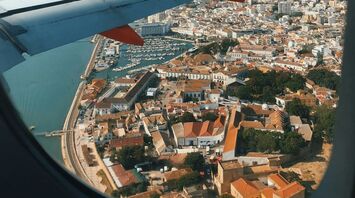 View of Faro city and harbor from an airplane window, showcasing the coastal town's charm