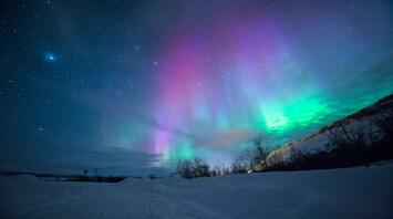 Northern Lights with vibrant colors over snowy landscape