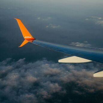 Jeju Air airplane wing in flight over clouds