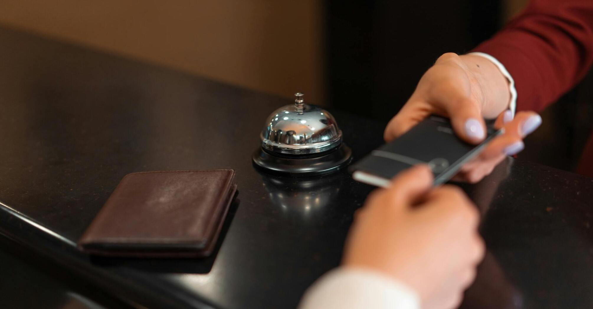 A guest checking into accommodation at a reception desk