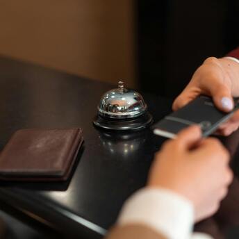 A guest checking into accommodation at a reception desk