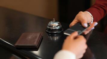 A guest checking into accommodation at a reception desk