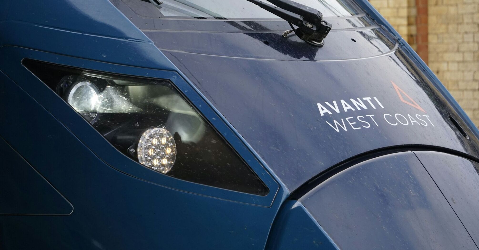 Front view of an Avanti West Coast train with headlights illuminated