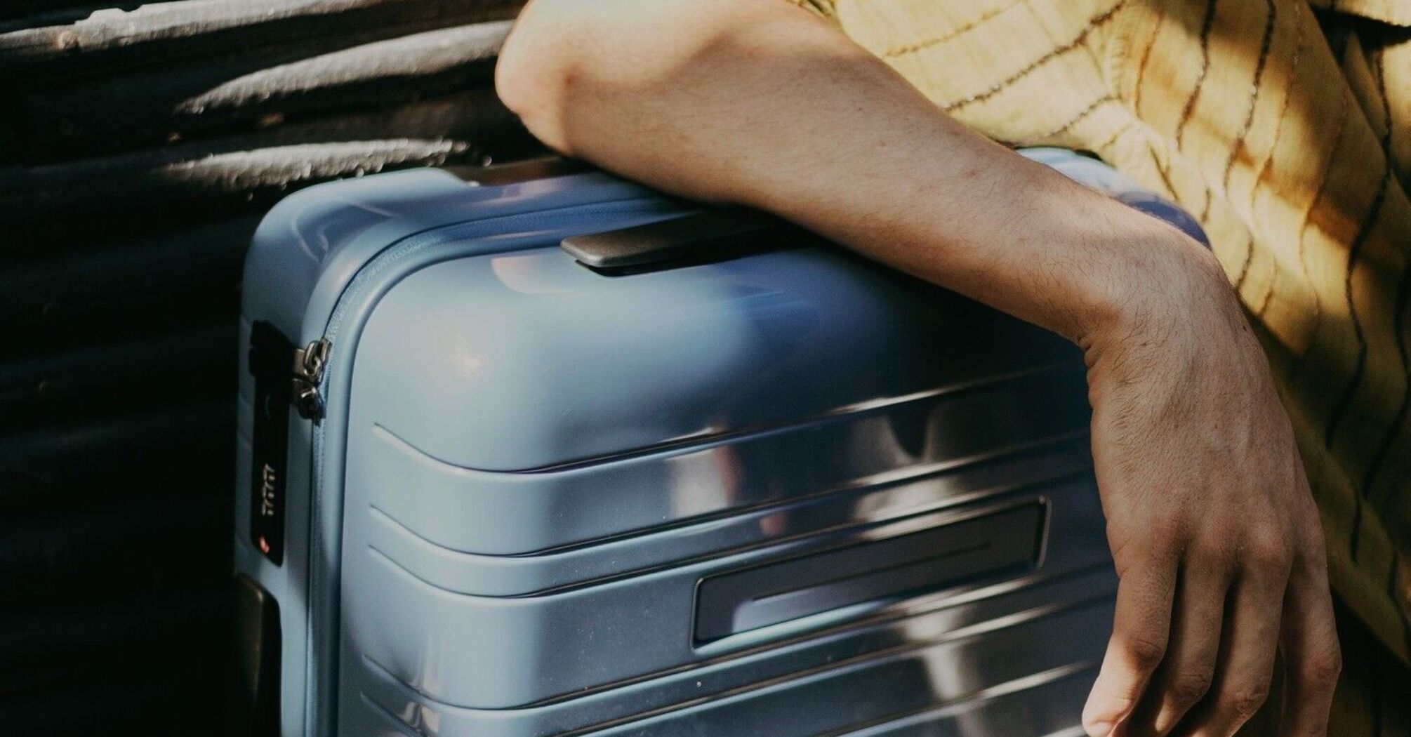 Traveler resting hand on secure suitcase