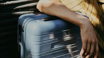 Traveler resting hand on secure suitcase