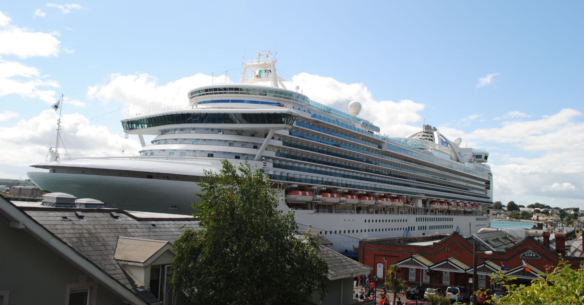 A large white cruise ship docked at a port