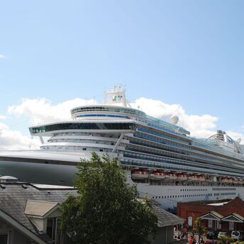 A large white cruise ship docked at a port