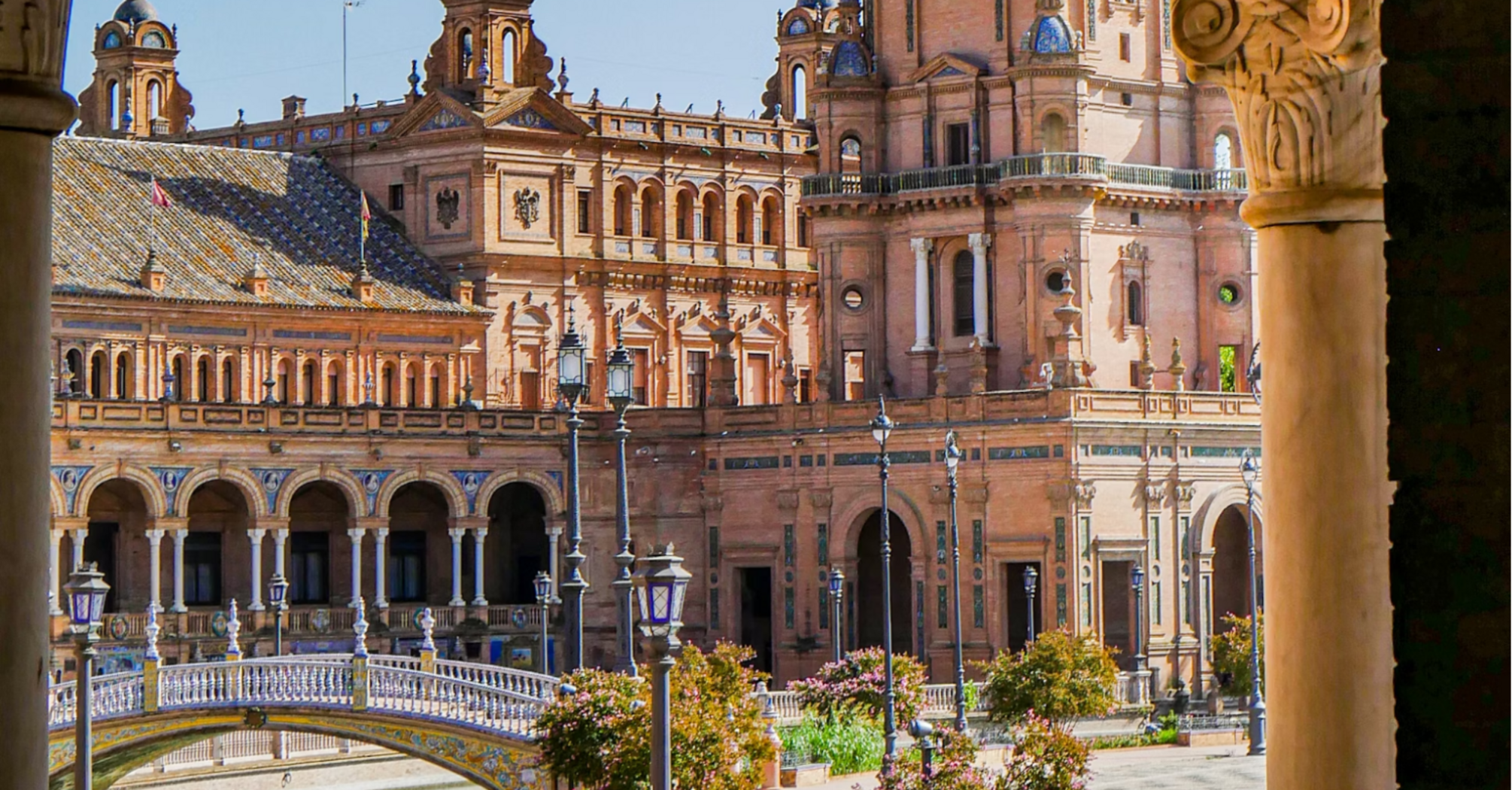 A picturesque view of Plaza de España in Seville, Spain, showcasing its iconic arches, bridges, and stunning architectural details