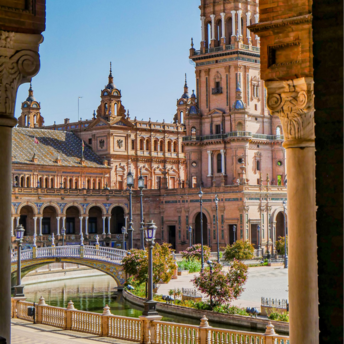 A picturesque view of Plaza de España in Seville, Spain, showcasing its iconic arches, bridges, and stunning architectural details