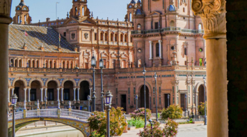 A picturesque view of Plaza de España in Seville, Spain, showcasing its iconic arches, bridges, and stunning architectural details