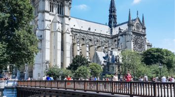 Notre-Dame Cathedral with a bridge in foreground on a sunny day