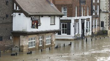 Flooded street near Rotherham Central station during heavy rainfall