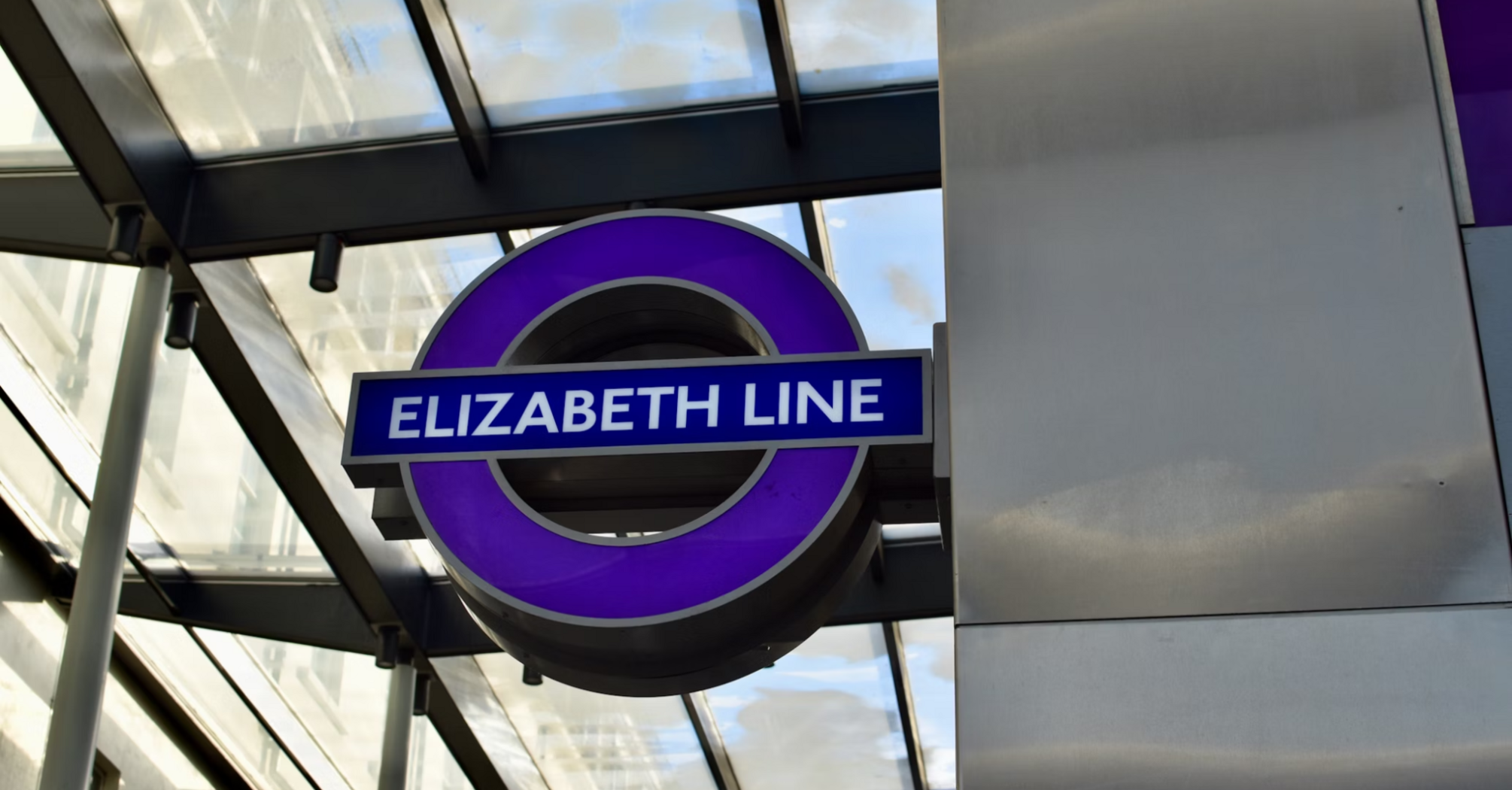 Purple Elizabeth Line logo under a glass canopy