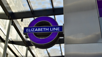 Purple Elizabeth Line logo under a glass canopy
