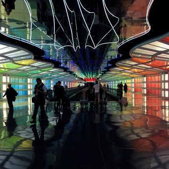 Colorful illuminated airport walkway with passengers in motion