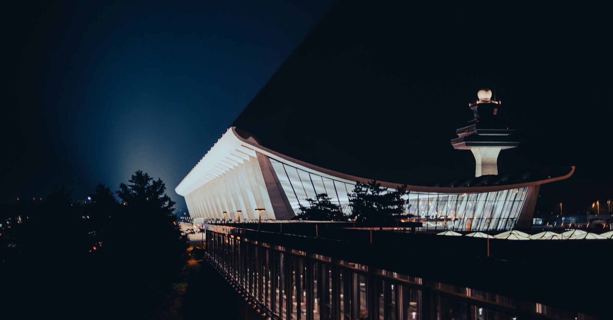 A night view of Washington Dulles International Airport showcasing its modern architectural design and iconic control tower