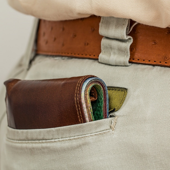 A close-up of a wallet filled with cash sticking out of a back pocket, emphasizing vulnerability  to pickpocketing