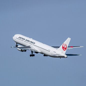 A Japan Airlines plane ascending into the sky, symbolizing global connectivity and sustainable travel initiatives