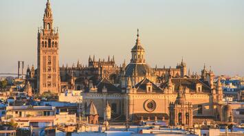 A scenic view of Seville Cathedral and La Giralda tower at sunset, symbolizing Spain's rich cultural heritage
